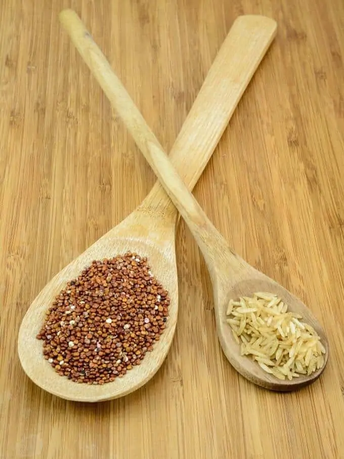 Photo of quinoa and rice in wooden spoons.