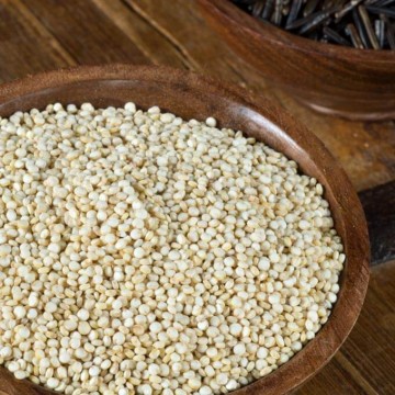 Photo of quinoa and rice in dark bowls on a dark background - quinoa vs rice.