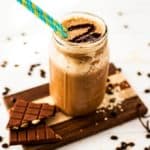  Vertikales Bild von Kaffee Quinoa Smoothie in einem Einmachglas sitzt auf einem Schneidebrett.