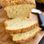 Square photo of Gluten Free Quinoa Bread sitting on a cutting board.