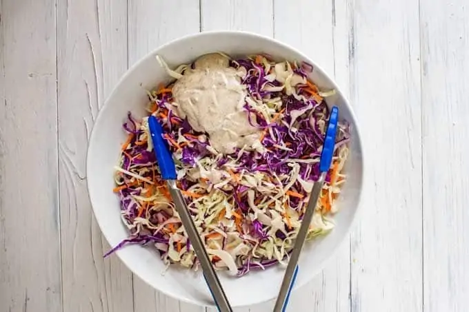 Photo of dressing being poured over slaw.
