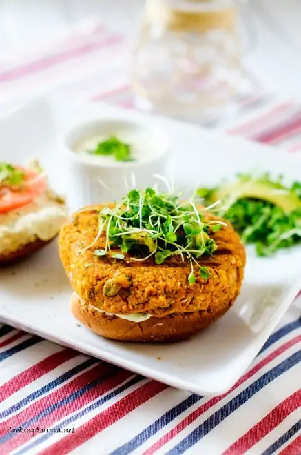Side photo of Sweet Potato Burgers on a white plate sitting in a red, white, and blue napkin.