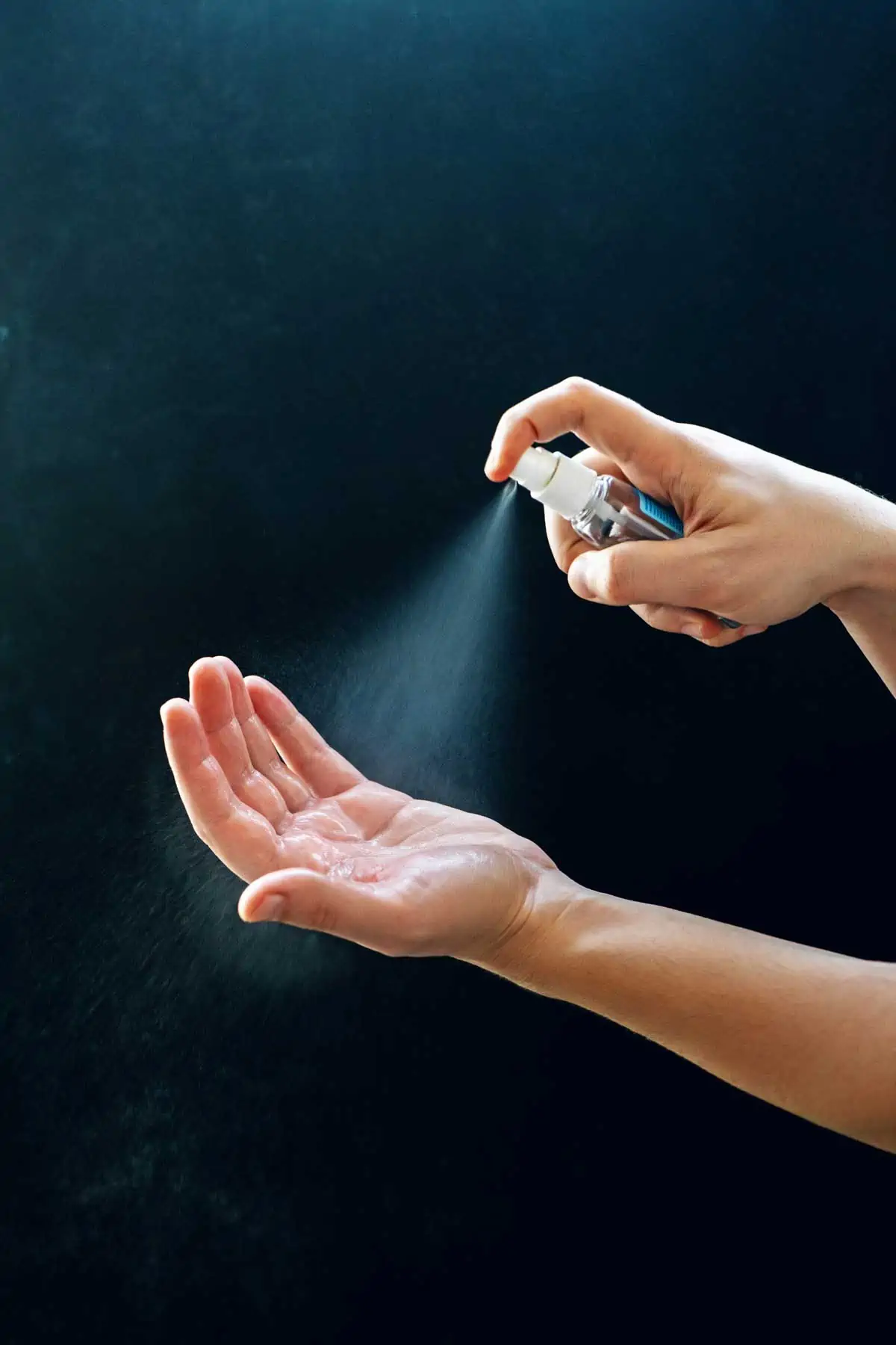 Photo of a hand being sprayed with DIY Antibacterial Spray for Skin.