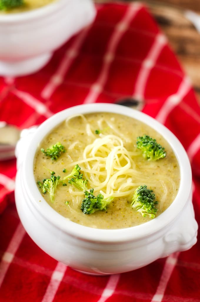 Photo of Slow Cooker Broccoli Cheese Soup in a white soup bowl sitting on a red and white napkin.