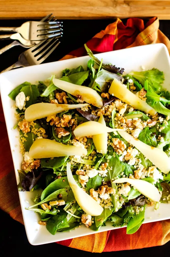 Photo of a white plate with a pear quinoa salad.