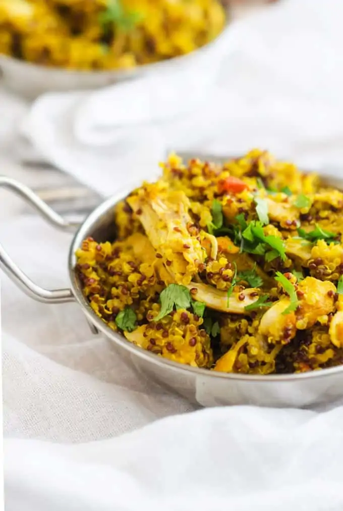 Side photo of Turmeric Chicken with Quinoa garnished with cilantro in a small metal dish. turmeric quinoa recipe. turmeric chicken and quinoa recipe.
