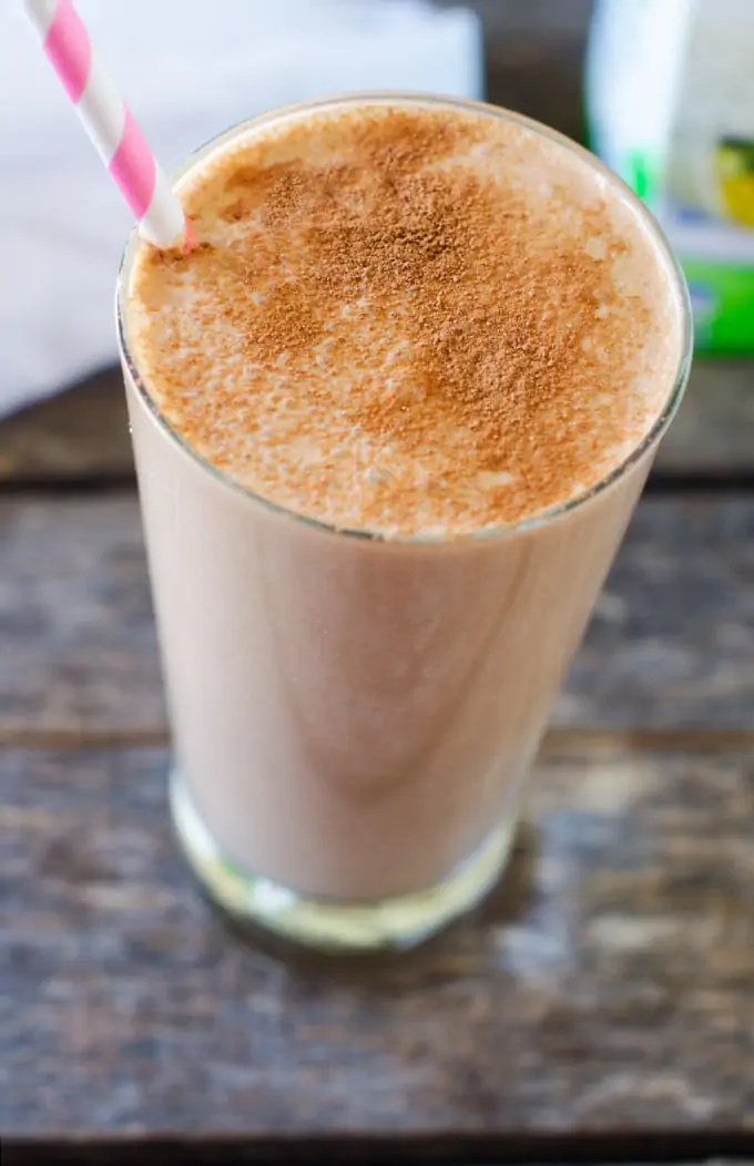 Photo of a Chocolate Banana Protein Smoothie on a dark background with a pink and white straw.