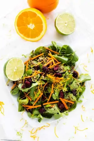 Overhead photo of citrus quinoa salad on a white background garnished with citrus peels.