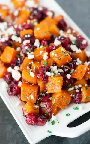 Photo of Honey Roasted Butternut Squash with Cranberries and Feta on a white serving platter.