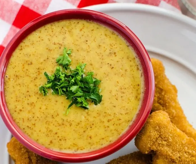 Photo of honey mustard dipping sauce in a red bowl.