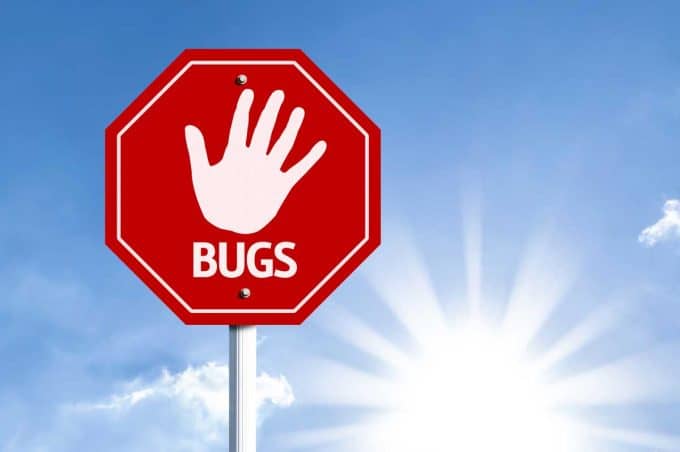 Red sign with a hand print and the word bugs beneath it.  (Stop Bugs)