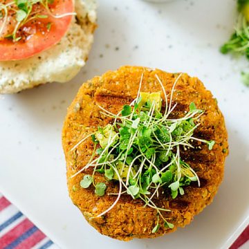 Square overhead photo of a sweet potato quinoa burger garnished with microgreens.