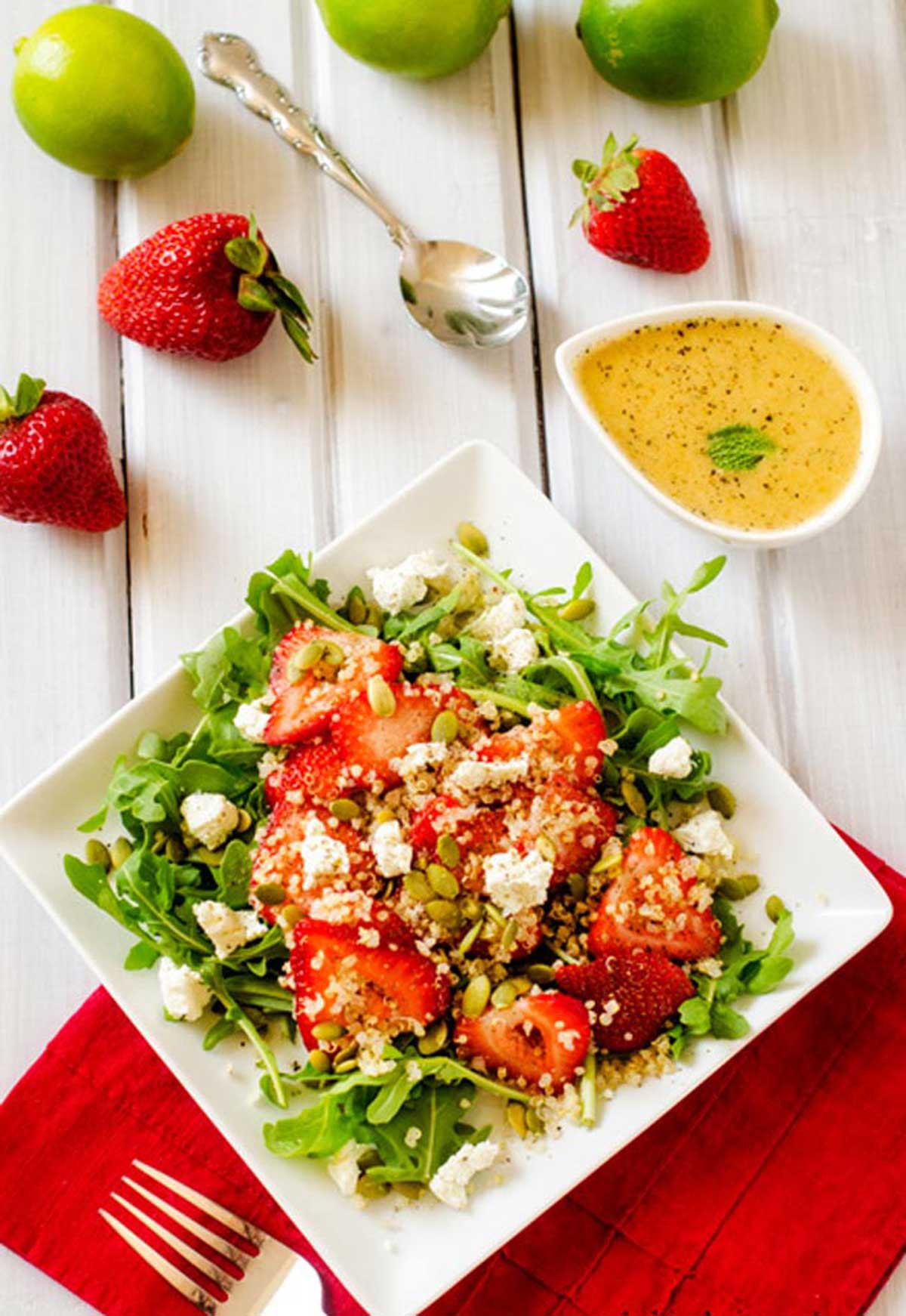 Overhead photo of a square plate with a strawberry quinoa salad.
