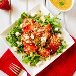 Photo of a square plate with a strawberry quinoa salad.