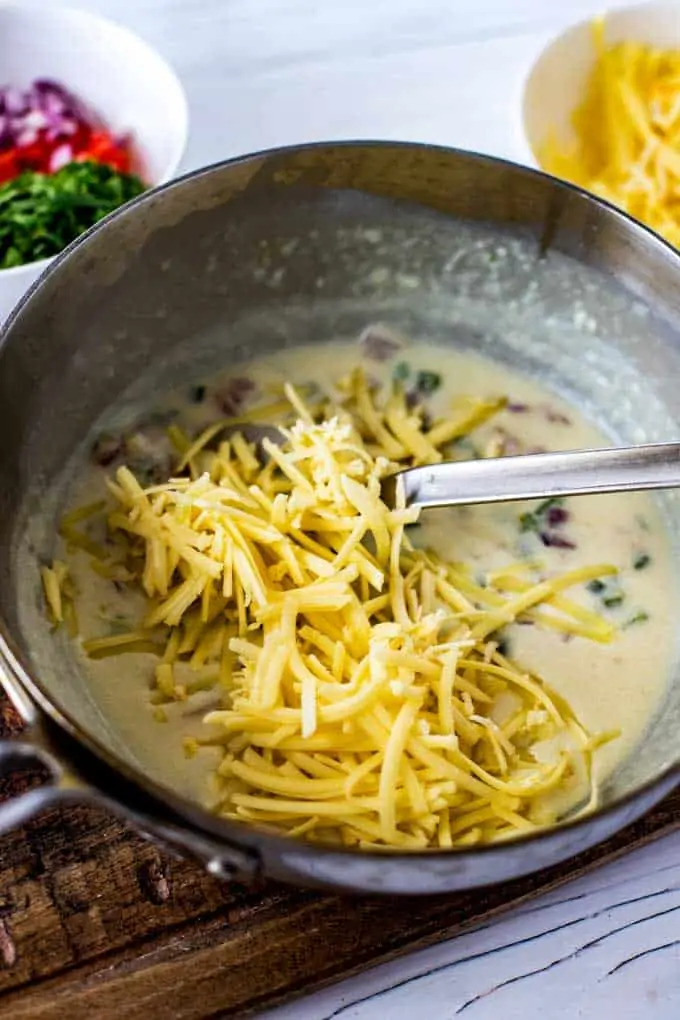 Photo of cheese being added to a homemade queso dip.