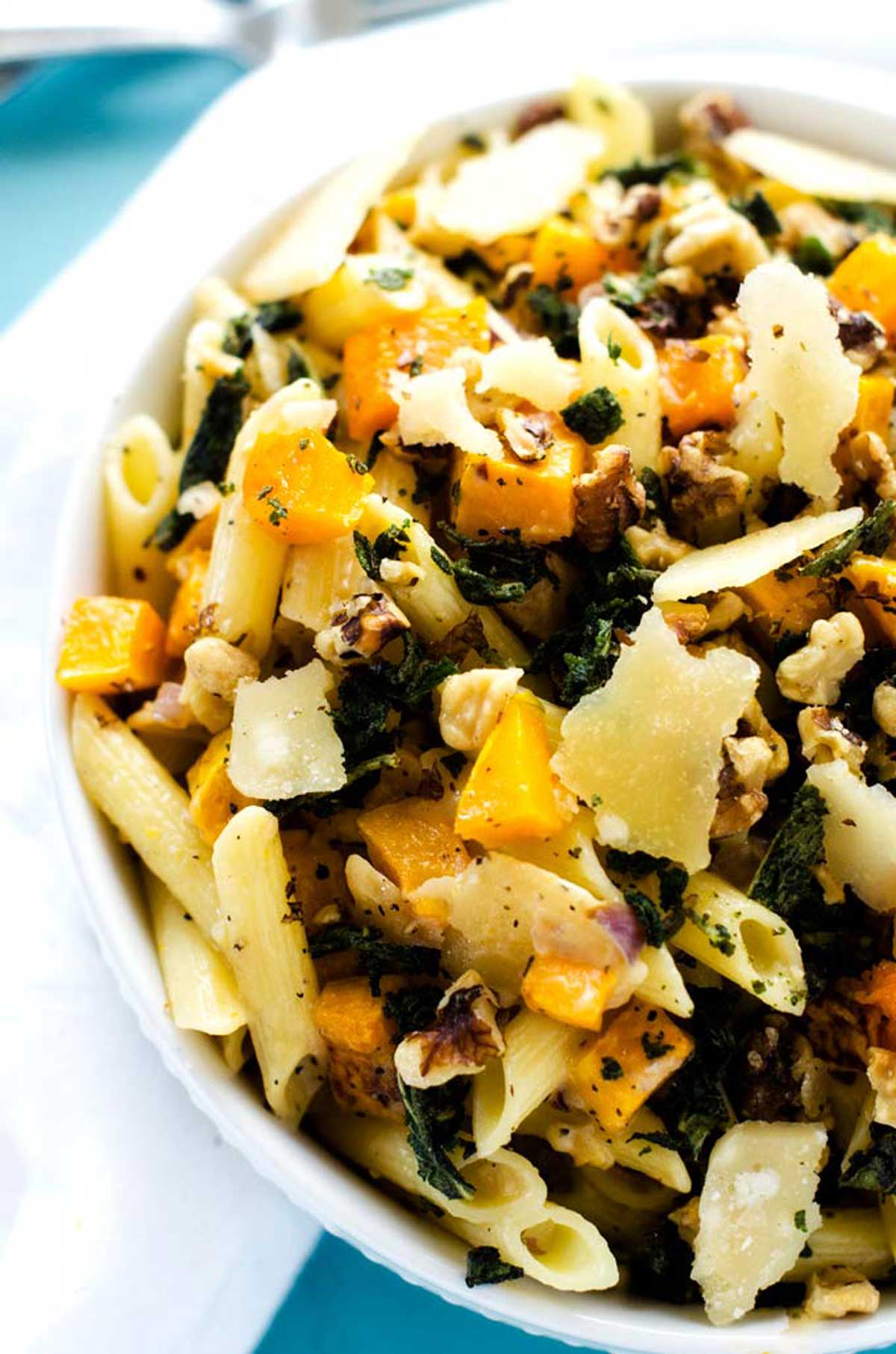 Close up overhead photo of a white bowl with roasted butternut squash pasta.