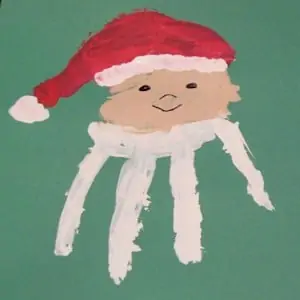 Photo of a simple Handprint Santa Craft for kids on a green piece of paper.
