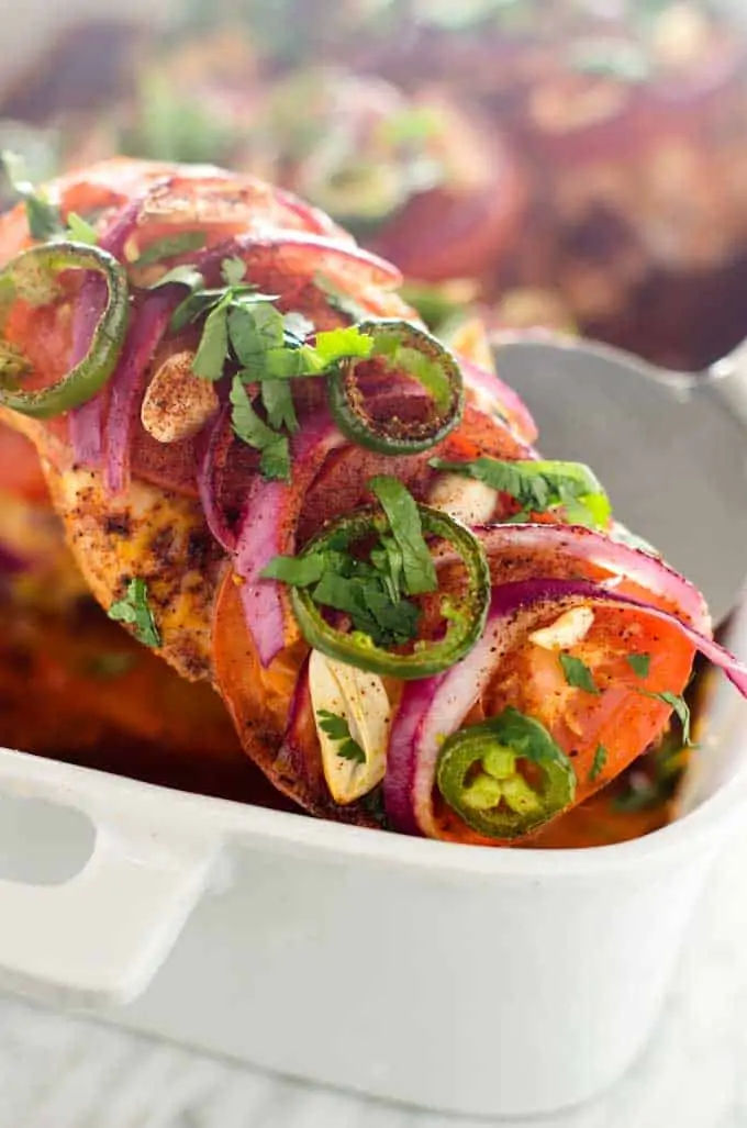 Close up photo of a cooked piece of southwest baked chicken garnished with cilantro.
