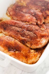 Photo of seasoned chicken breast in a casserole dish.