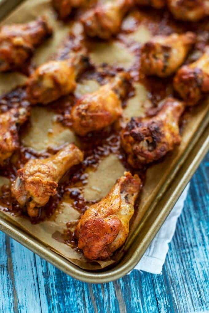 Photo of Baked Chicken Wings on a parchment lined baking sheet just out of the oven.