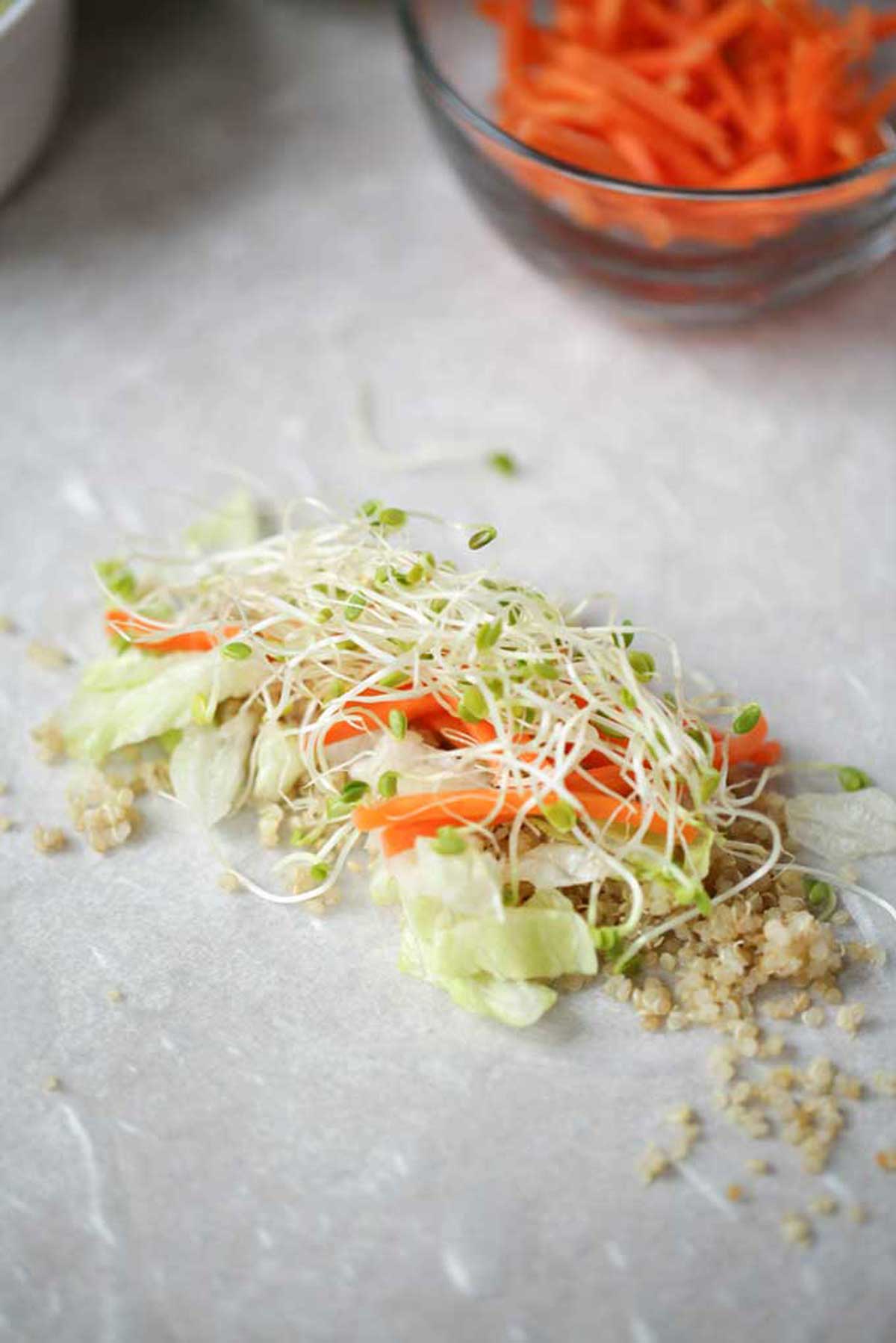 Photo of a summer roll wrapper with quinoa and veggies on top.