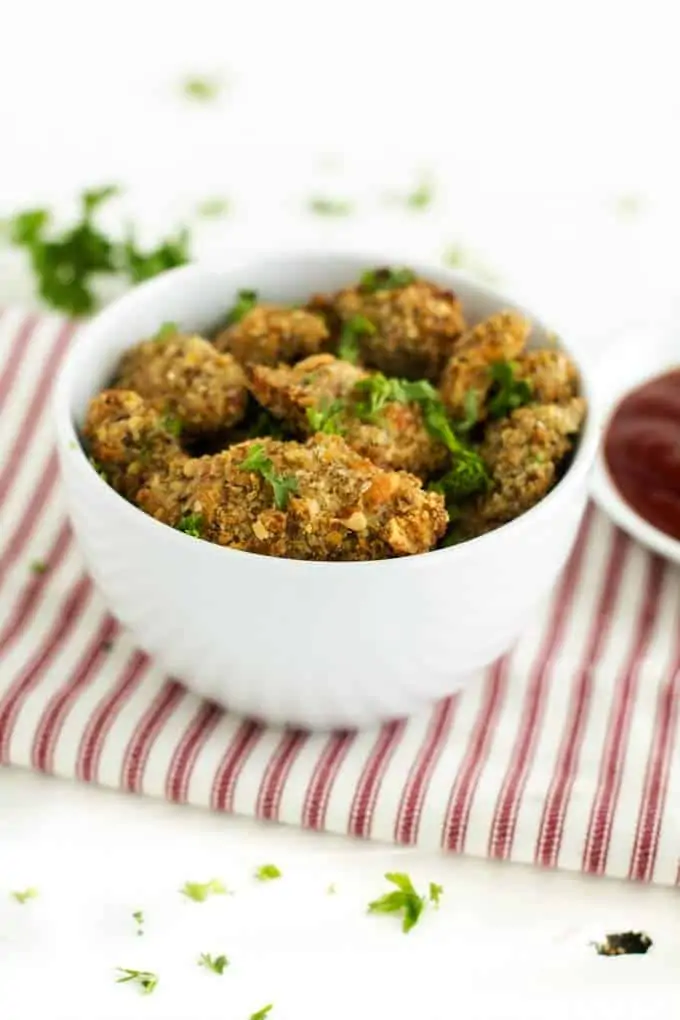 Photo of Healthy Chicken Nuggets in a white bowl garnished with parsley.