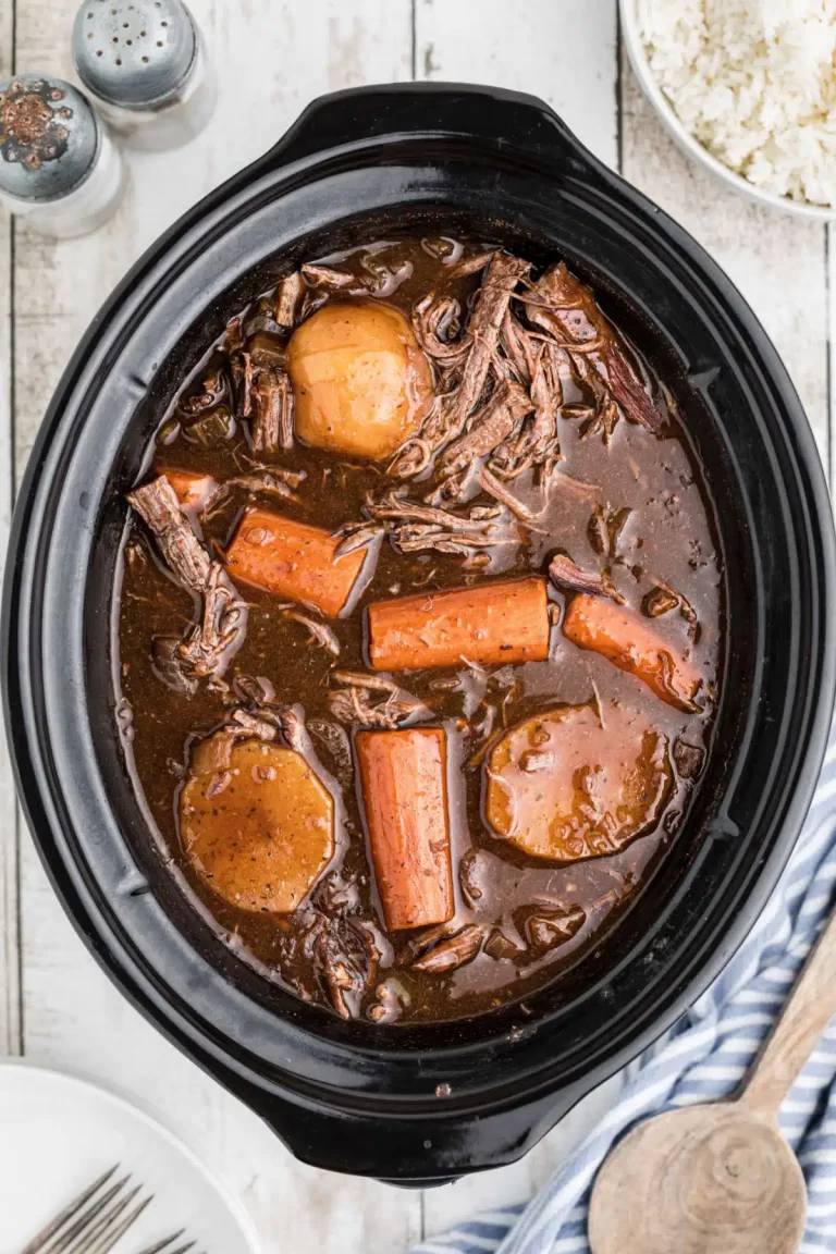 Overhead photo of a slow cooker venison roast in a black crockpot.