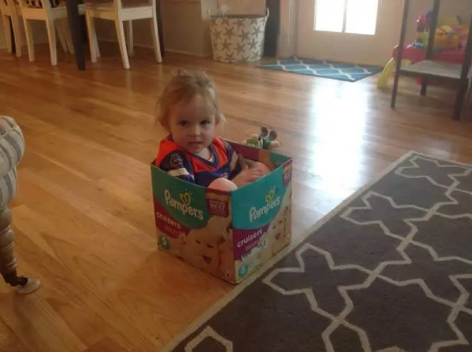 Toddler Girl sitting in Pampers Box