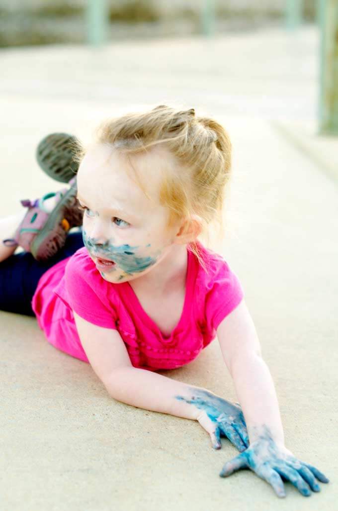 Toddler girl covered in paint