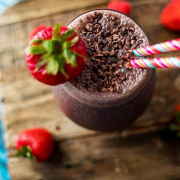 Overhead photo of Acai Smoothie garnished with cacao nibs and a strawberry.