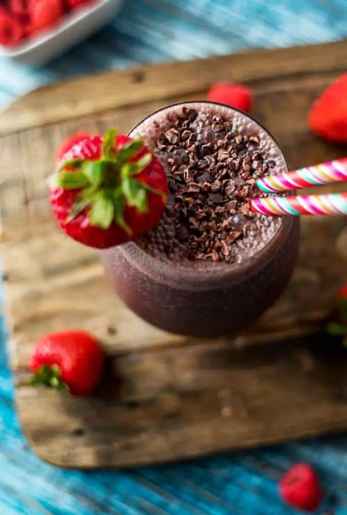 Overhead photo of Acai Smoothie garnished with cacao nibs and a strawberry.
