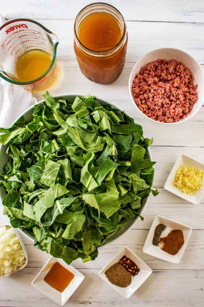 The ingredients for Slow Cooker Collard Greens measured out in prep bowls against a white background.