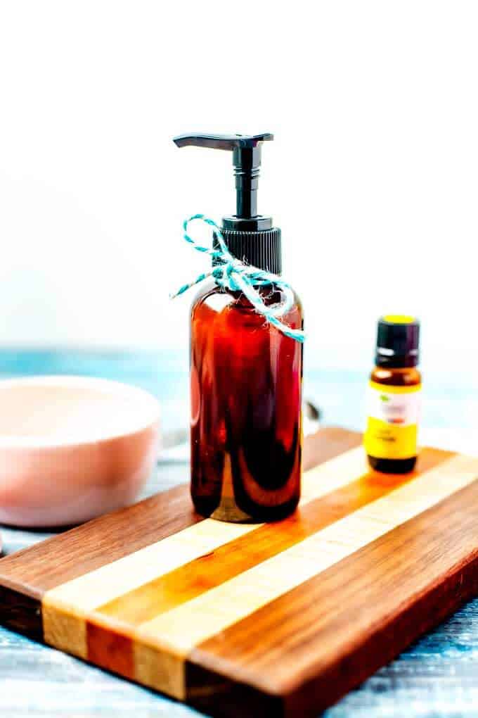 Photo of Homemade Furniture Polish in an amber glass jar with a bottle of lemon essential oil.