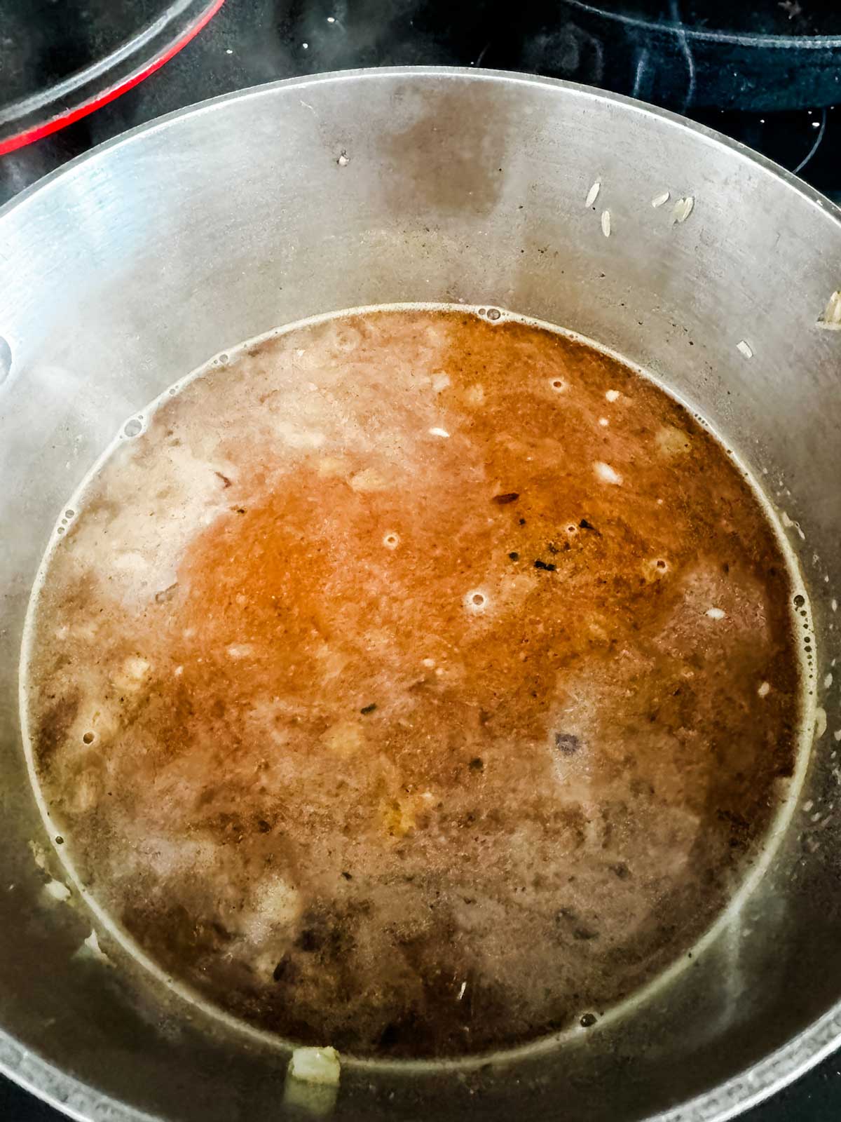 Brown rice cooking in broth.