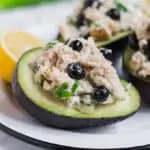 Photo of avocado stuffed with chicken salad and blueberries with a lemon wedge