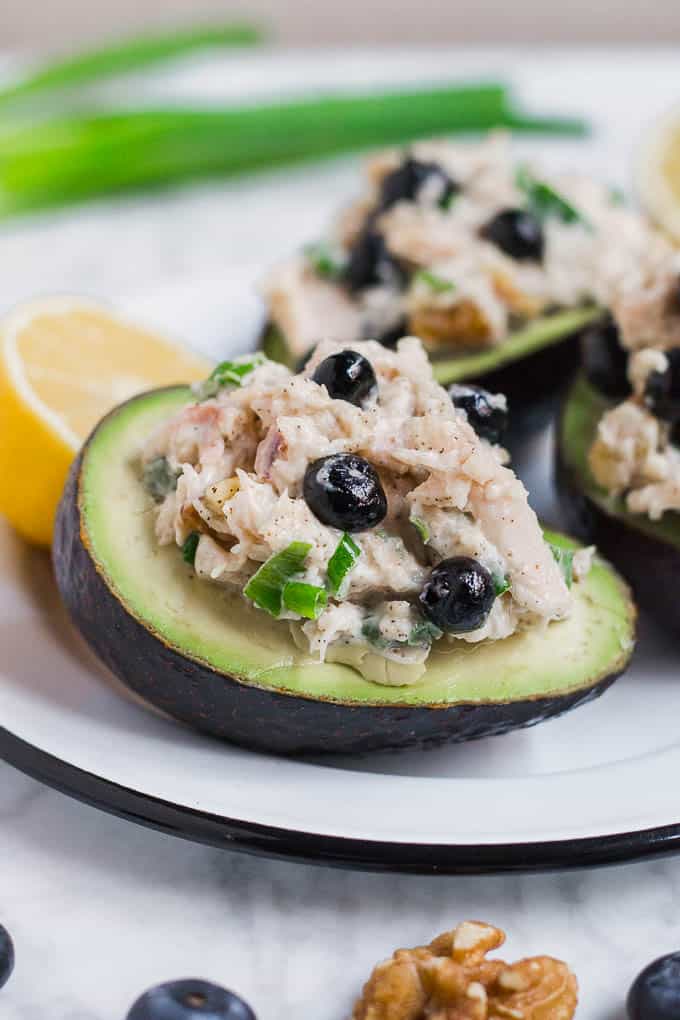 Photo of avocado stuffed with chicken salad and blueberries with a lemon wedge
