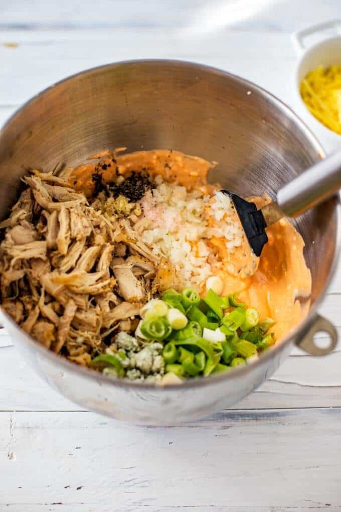 Photo of ingredients for a Low Fat Buffalo Chicken Dip being mixed together in a large mixing bowl.