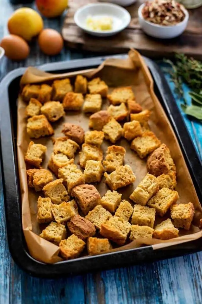 Photo of a baking sheet with toasted bread cubes on it.