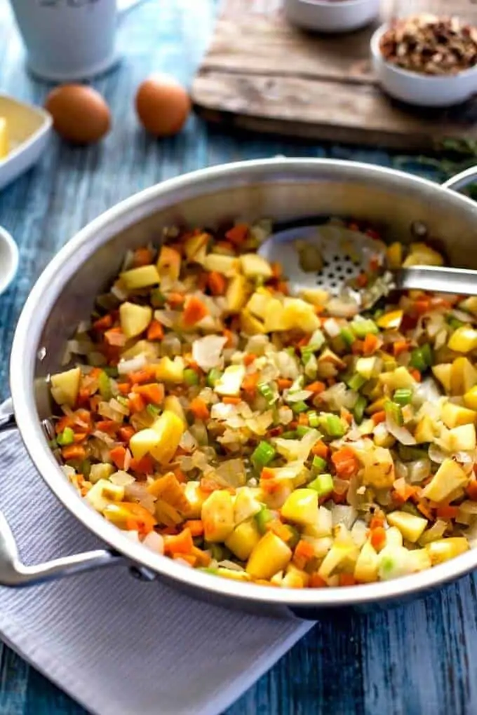 Skillet with onion, carrot, celery, and apple cooking.