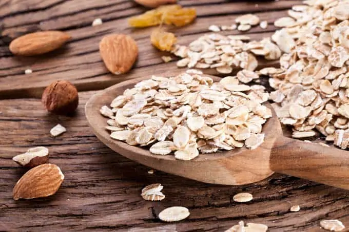 Photo of oats and almonds on a dark background.