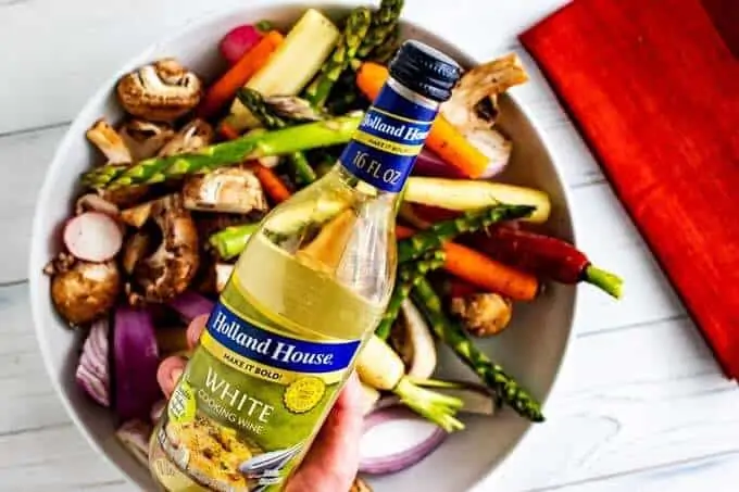 Photo of Holland House White Cooking Wine over a bowl of spring vegetables.