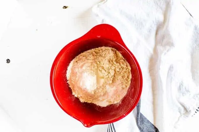 Photo of flours, baking powder, and salt in a red bowl.