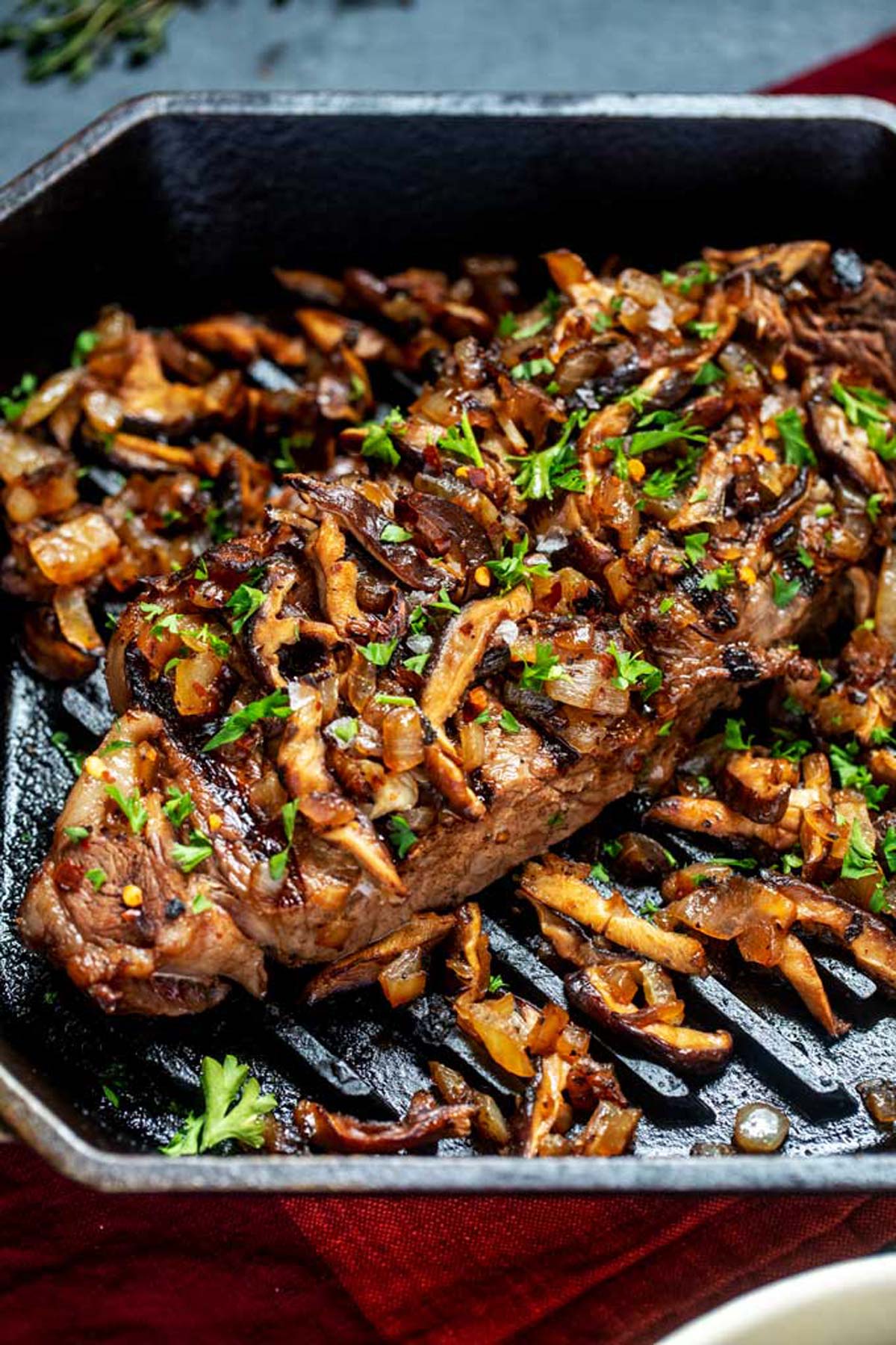 Close up photo of Steak and Mushrooms in a cast iron grill pan.