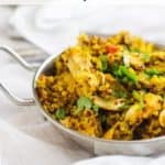 Photo of turmeric chicken with quinoa in a small metal dish against a white background with the recipe title above it.