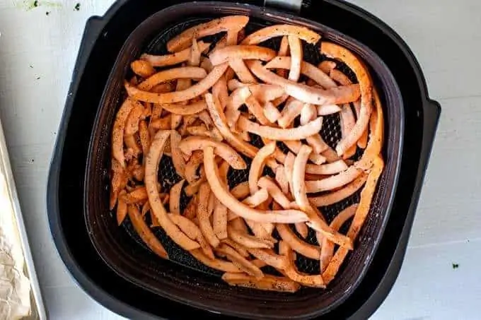 Photo of sweet potato fries in an air fryer.