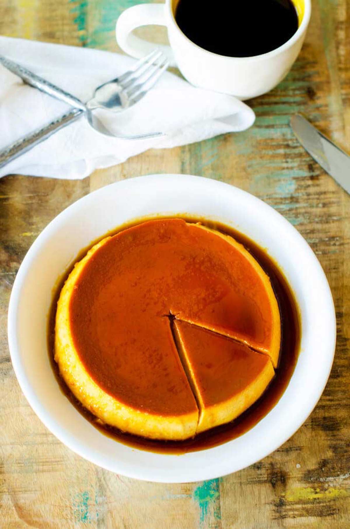 Photo of Pumpkin Flan on a white plate against a rustic wood background.