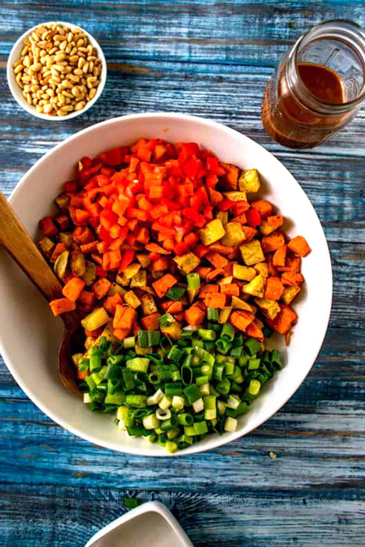 Photo of sweet potatoes with red pepper and scallions in a large bowl.