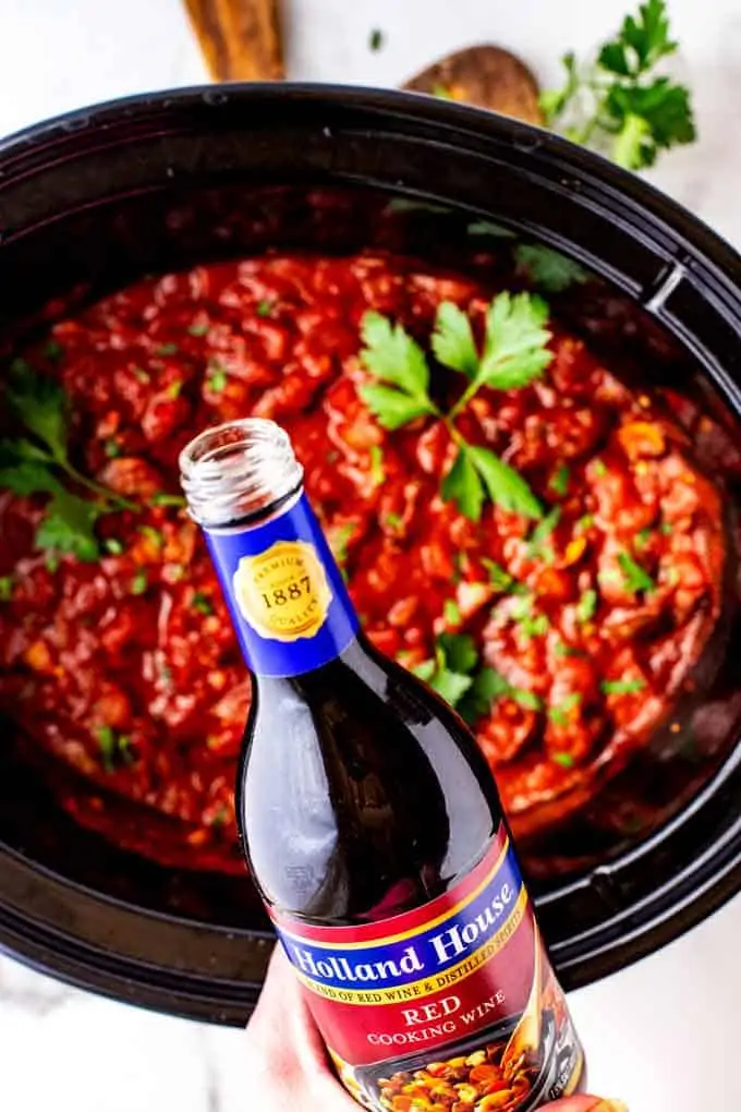 Photo of Holland House Red Cooking Wine being poured into a slow cooker with Mushroom Bolognese.