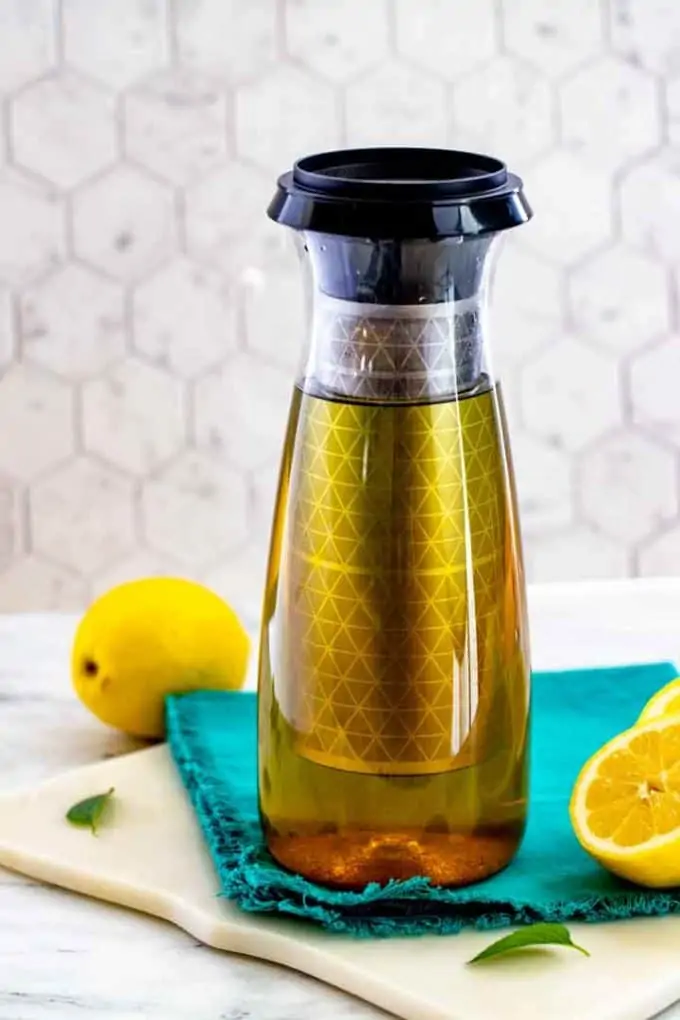 Photo of a tupperware cold brew carafe with tea in it surrounded by lemons.