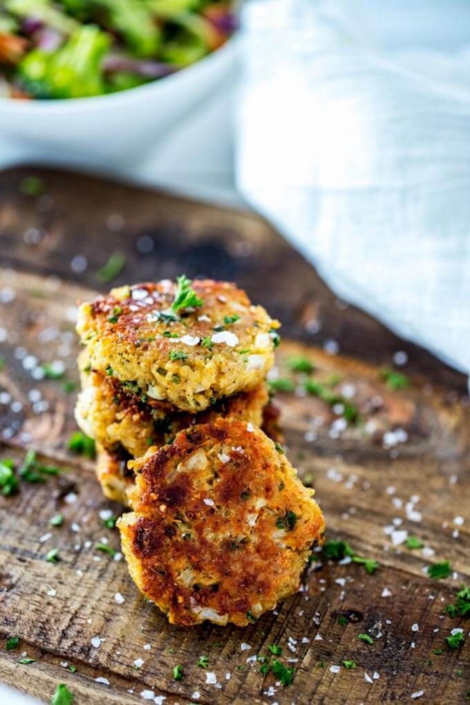 Photo of three stacked quinoa patties with one quinoa patty leaning on the stack.